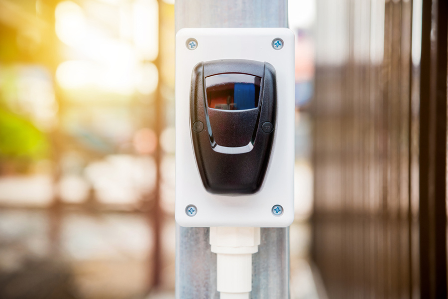 close up of an outdoor sensor next to a fence.